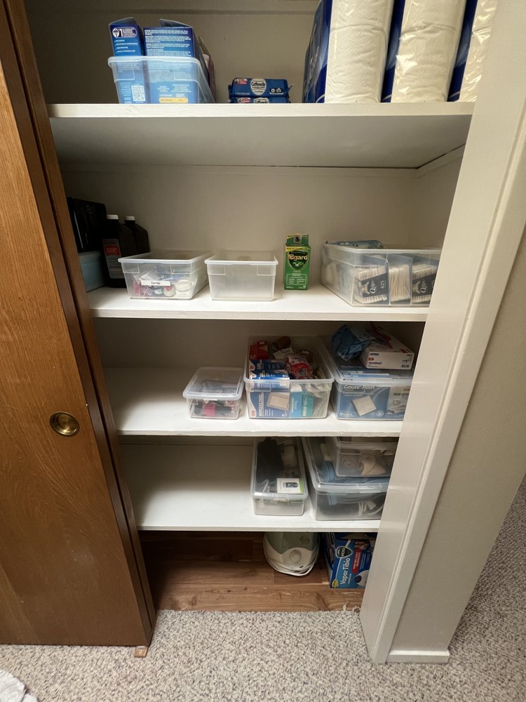 Efficiently organized bathroom hall closet with toiletries and cleaning supplies grouped by category