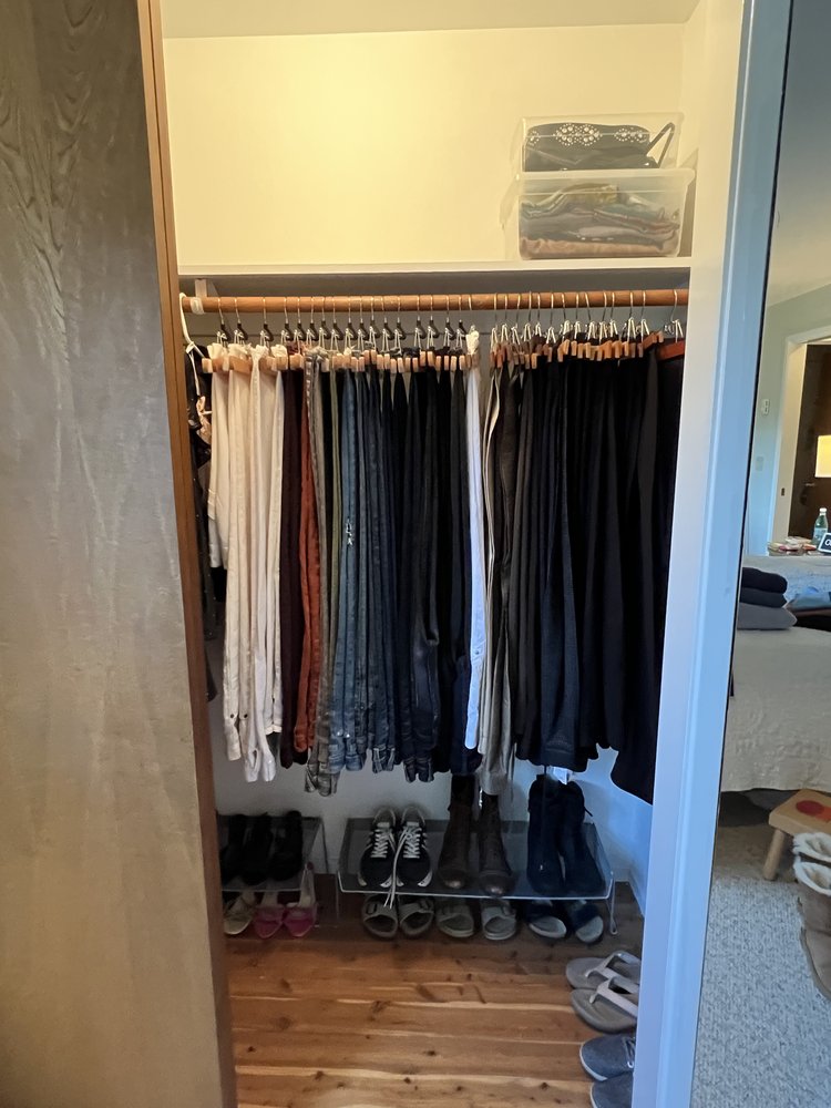 Spacious deep reach-in closet with organized clothing and clear pathways
