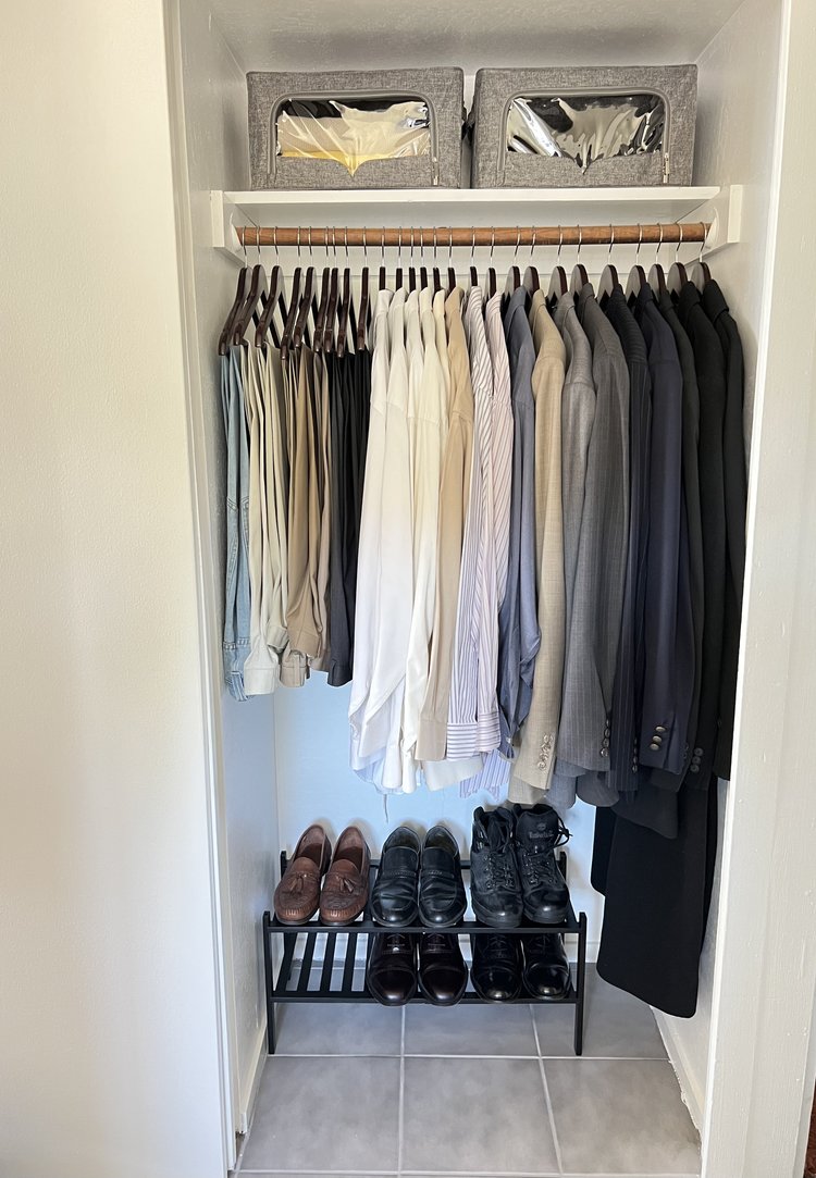 Streamlined reach-in closet organized with business wear, suits and dress shirts hung neatly, and dress shoes on shoe racks