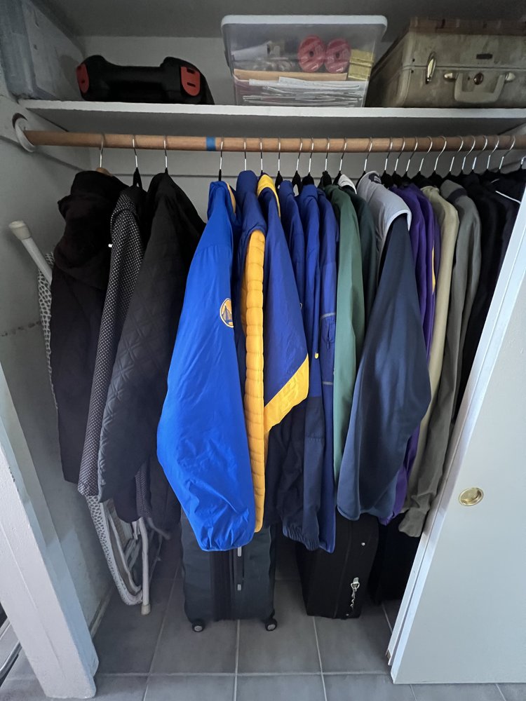 Streamlined reach-in hall closet with seasonal rotation system and clear storage box for easy visibility