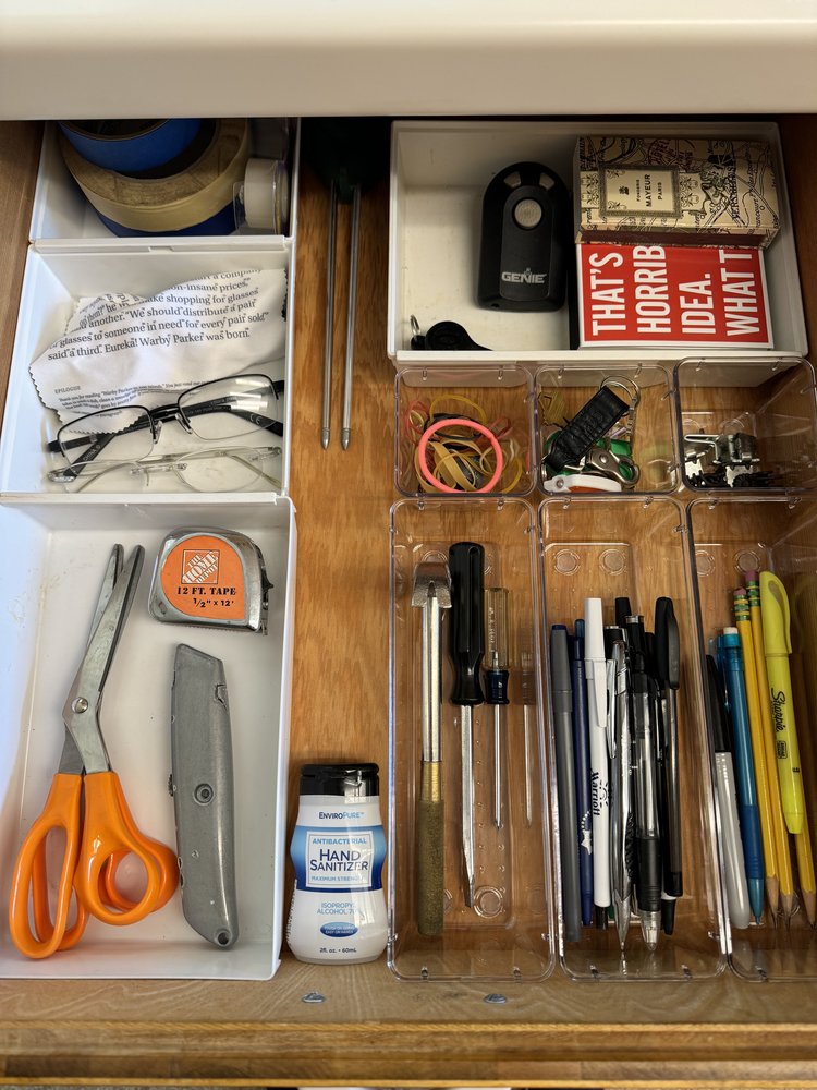 Organized kitchen utility drawer with compartmentalized storage for batteries, office supplies, and household essentials
