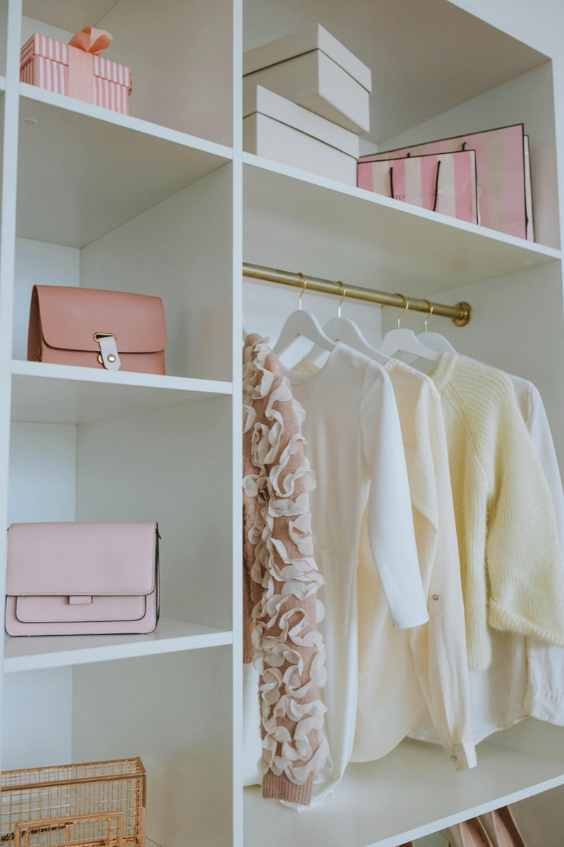 Professional organizer guiding client through KonMari Method, sorting clothing items by category to determine what sparks joy